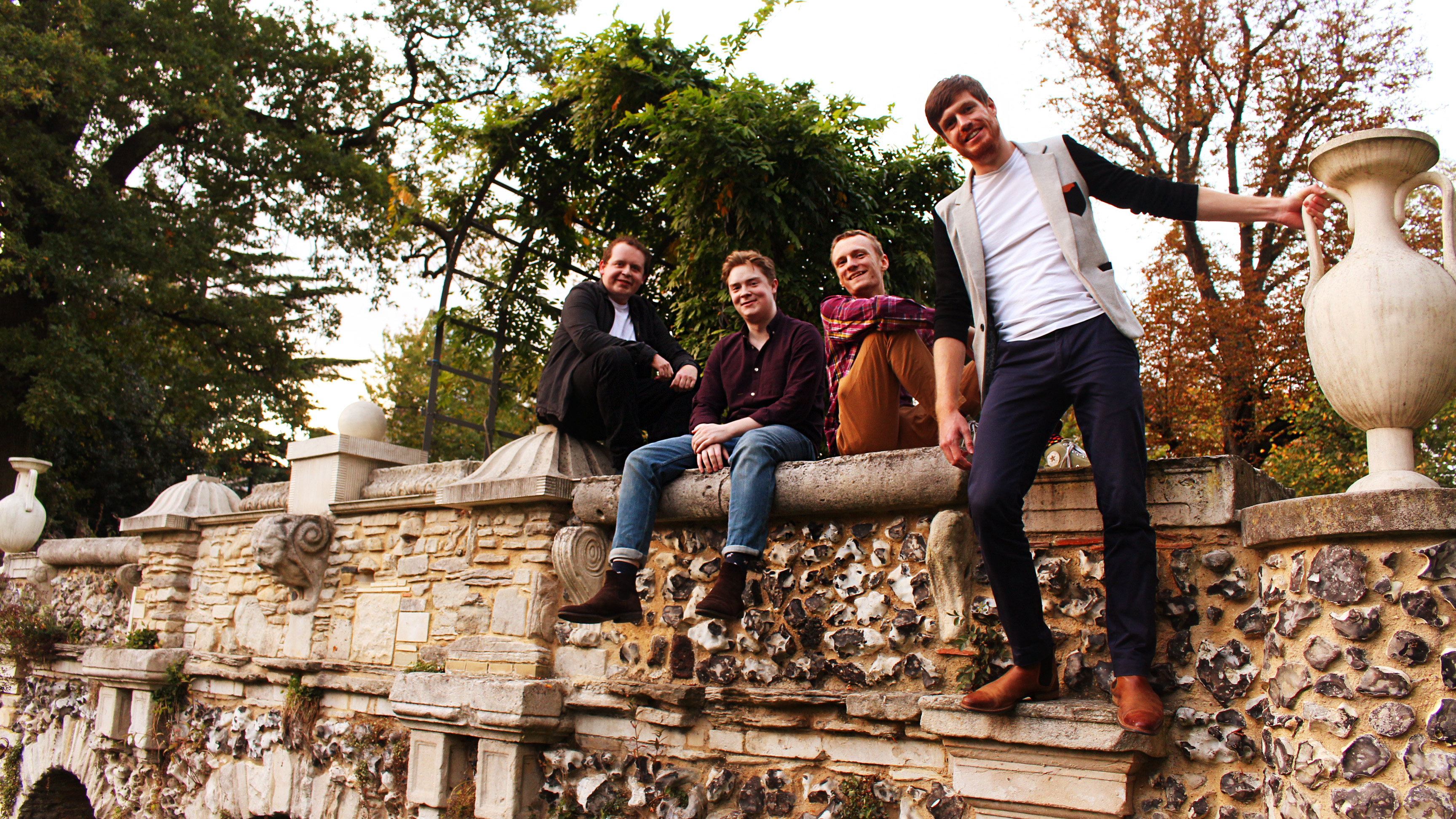 On That Note quartet perched on a garden wall beside an urn
